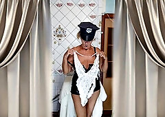 An older dame in the kitchen dressed in an infatuating suit